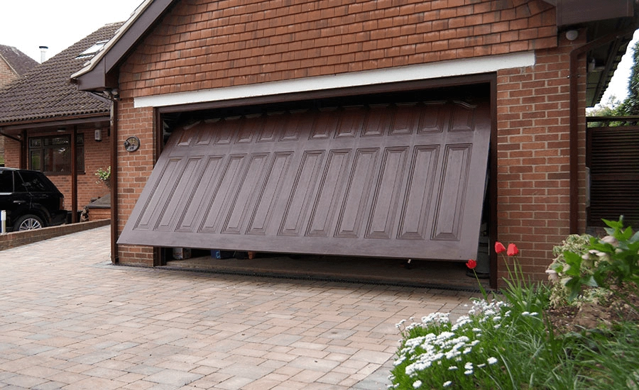 Kovinska rjava garažna vrata, ki se v enem kosu dvigujejo pod strop.