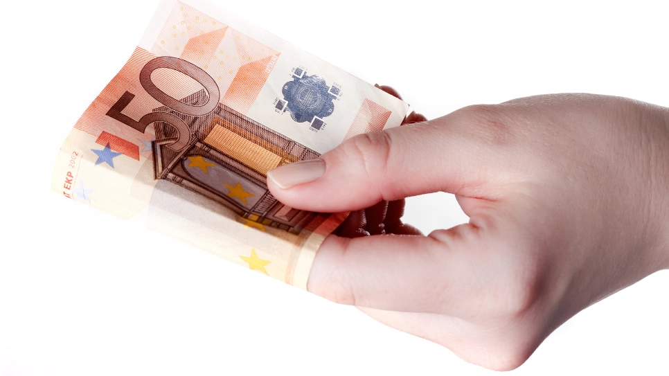 ženska roka drži bankovec za 50 evrov