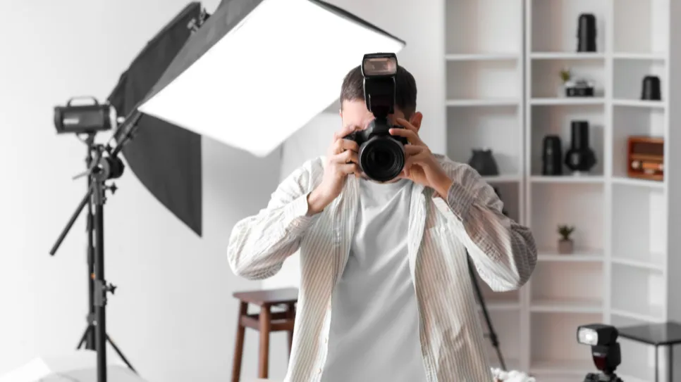 fotograf slika s fotoaparatom v studiu