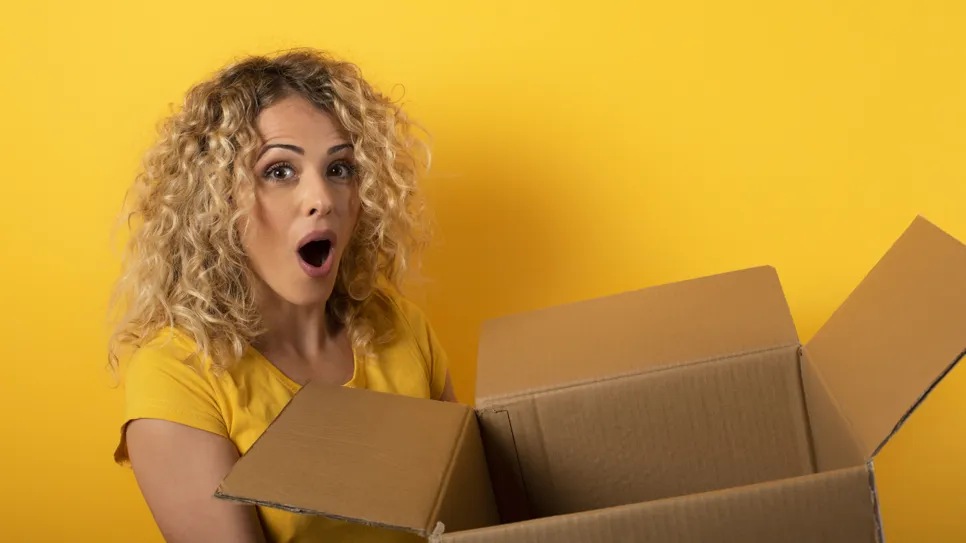 Dekle je navdušeno nad izdelkom iz škatle, ki ga je prejelo iz spletne trgovine.