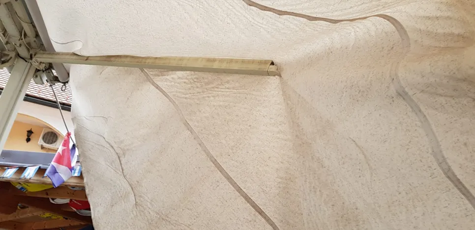 Sagging fabric on retractable awning causing uneven coverage and potential damage at outdoor patio.