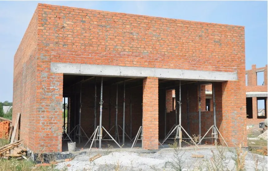 Zidana garaža z odprtinama za dvoja garažna vrata z jasno vidnimi prekladami