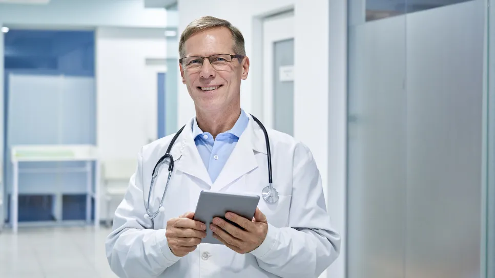 doktor medicine s tablico z nasmehom čaka na paceinta