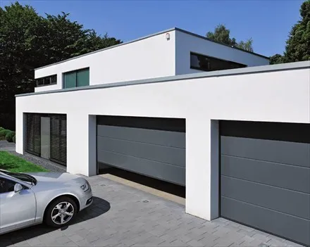 Dve garaži s sivimi sekcijskimi vrati