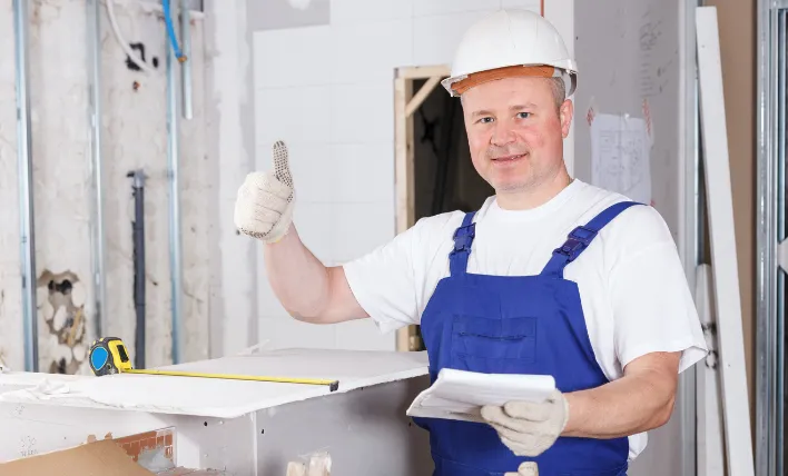 Zadovoljen obrtnik drži dvignjen palec.