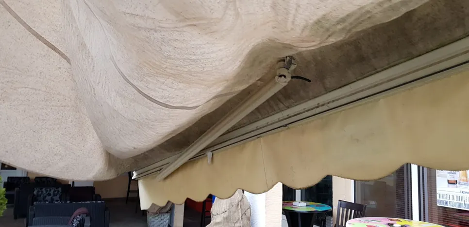 Sagging fabric on a patio awning indicates potential water pooling or structural issues.