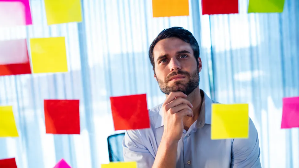 Mladi podjetnik gleda "post it" listke.