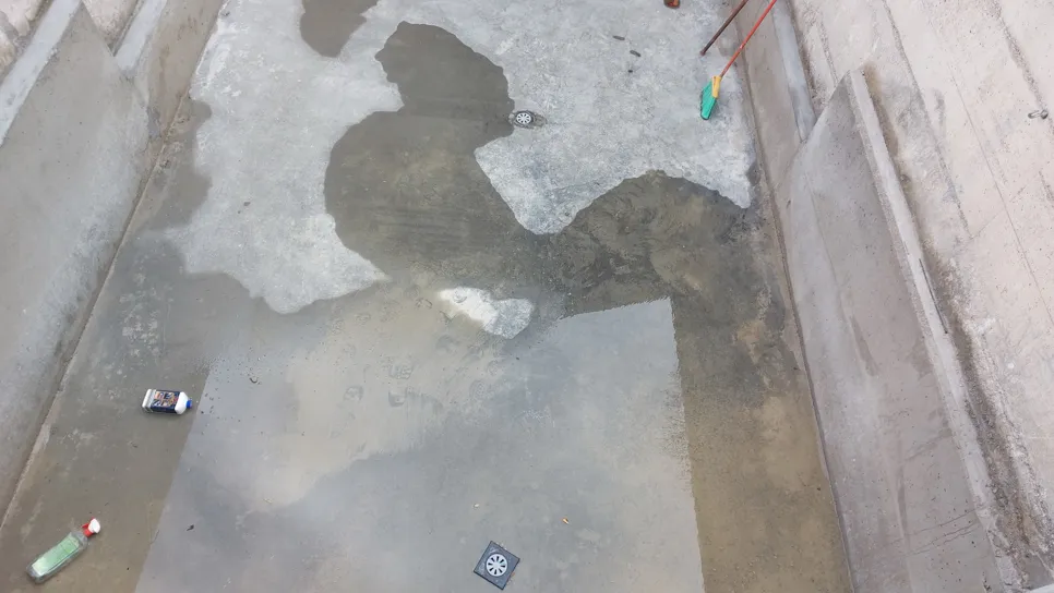 Standing water on a basement floor indicates a potential water drainage issue or seepage problem.