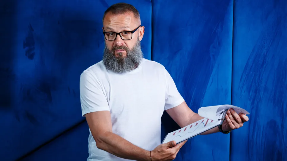 moški se sumičavo ozira na papirne dokumente