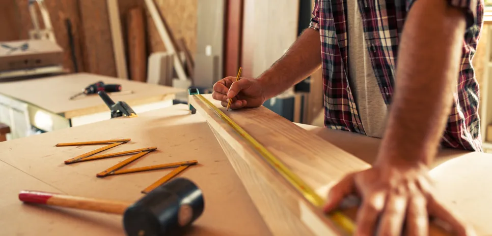 Mizar na delovnem pultu meri desko.