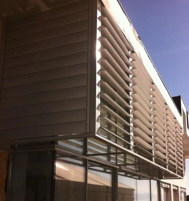 Brisole senčila na moderni zgradbi z velikimi steklenimi površinami.